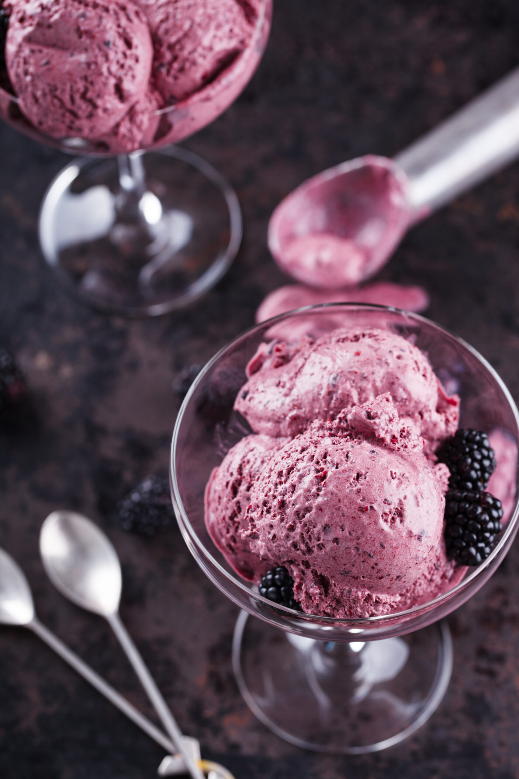 BlackBerry ice cream with fresh blackberries in a glass sundae dish. selective focus